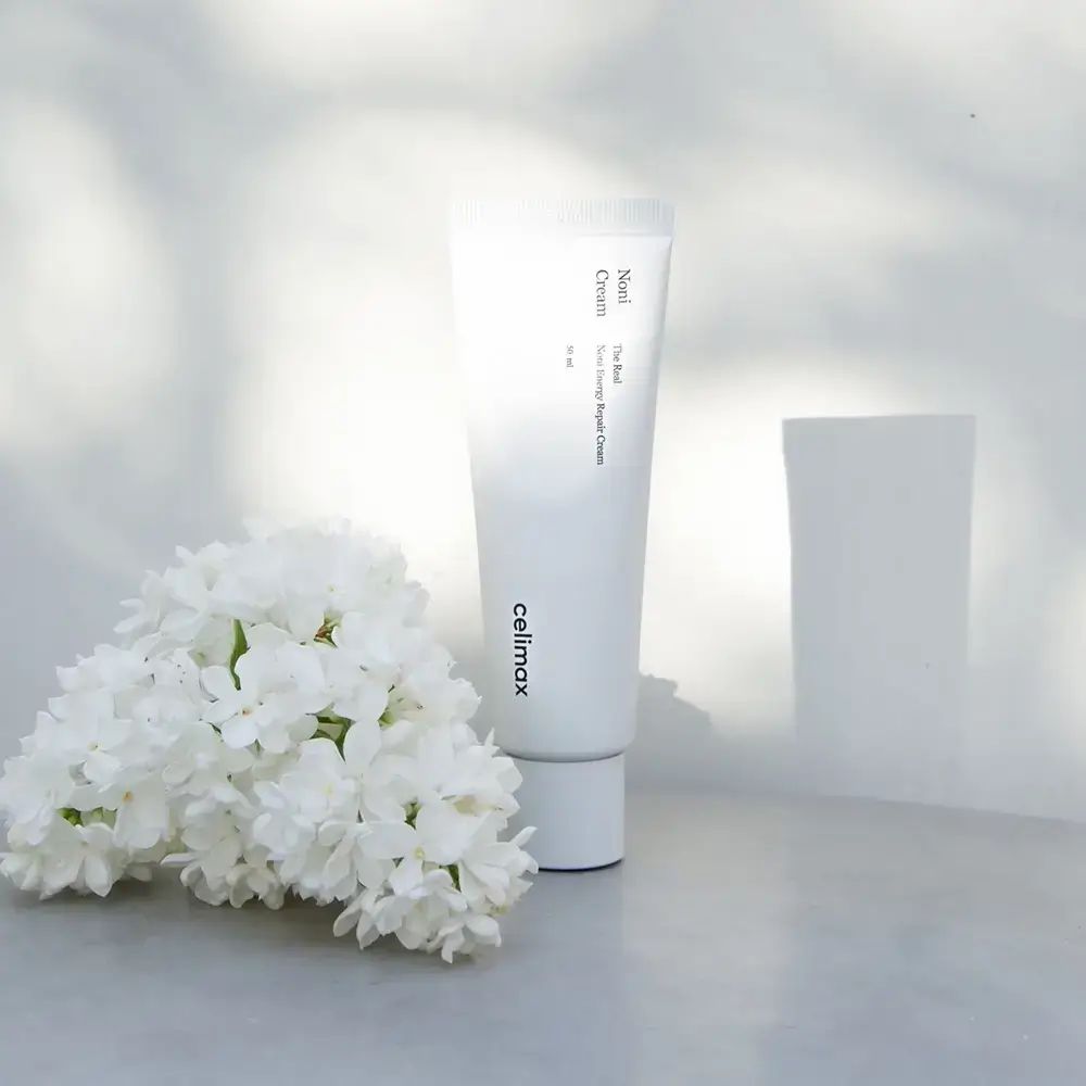 Weiße Tube mit Produktnamen und Marke. Weiße Blüten und heller Hintergrund. 50 ml.