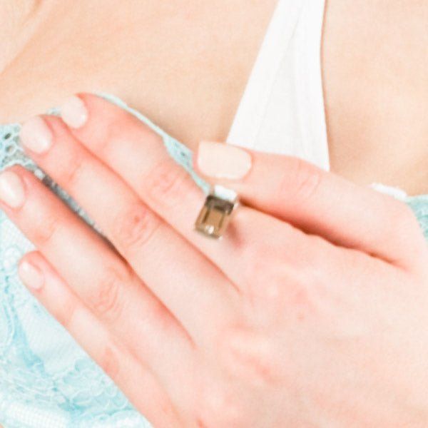 Helle Haut mit hellblauem BH-Detail. Hand mit Ring. 