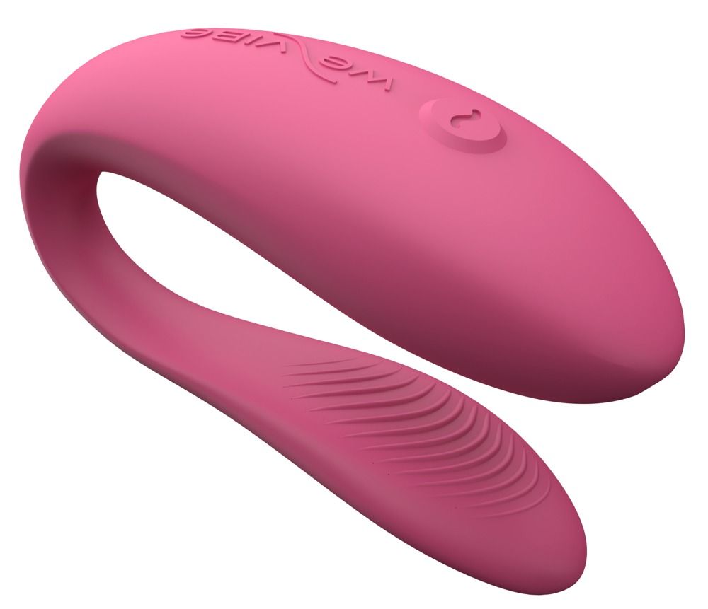 Rosa Vibrator mit geschwungener Form. Oberseite mit geriffelter Textur. Auf weißem Hintergrund.