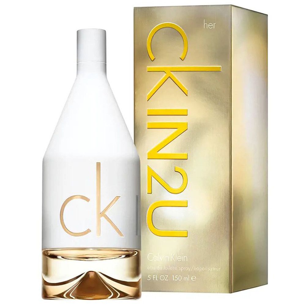 Calvin Klein CK In2U Her Eau de Toilette Spray Flakon neben der goldenen Verpackung.
