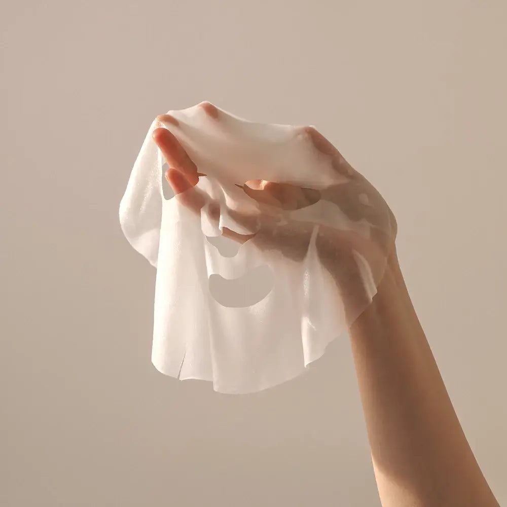 Hand hält eine transparente Gesichtsmaske. Auf hellem Hintergrund.