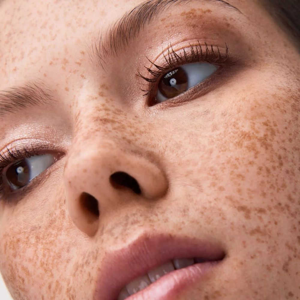 Nahaufnahme eines Gesichts mit geschminkten Augen. Der Lidschatten ist in Brauntönen gehalten.