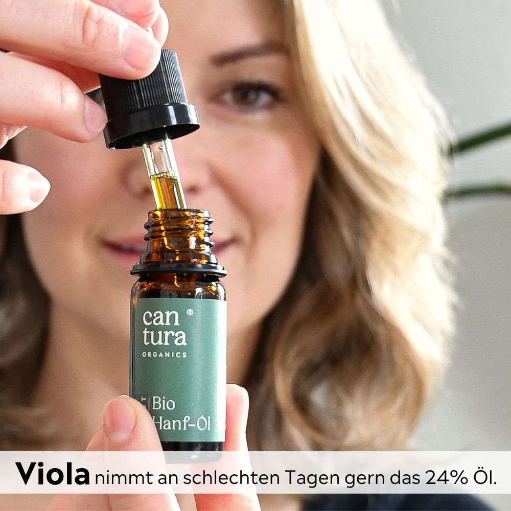 Hände halten Flasche mit Tropfer. Tropfen Öl. Aufschrift: can tura, Bio Hanf-Öl.