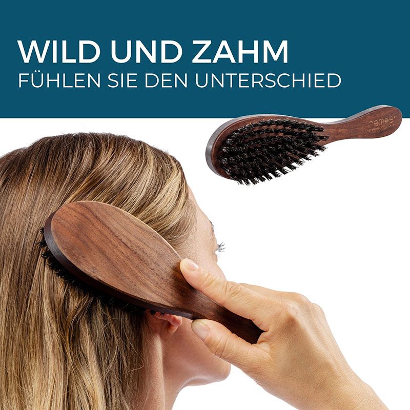 Haarbürste aus Nussbaumholz mit Wildschweinborsten. Die Bürste wird am Kopf einer Person verwendet.