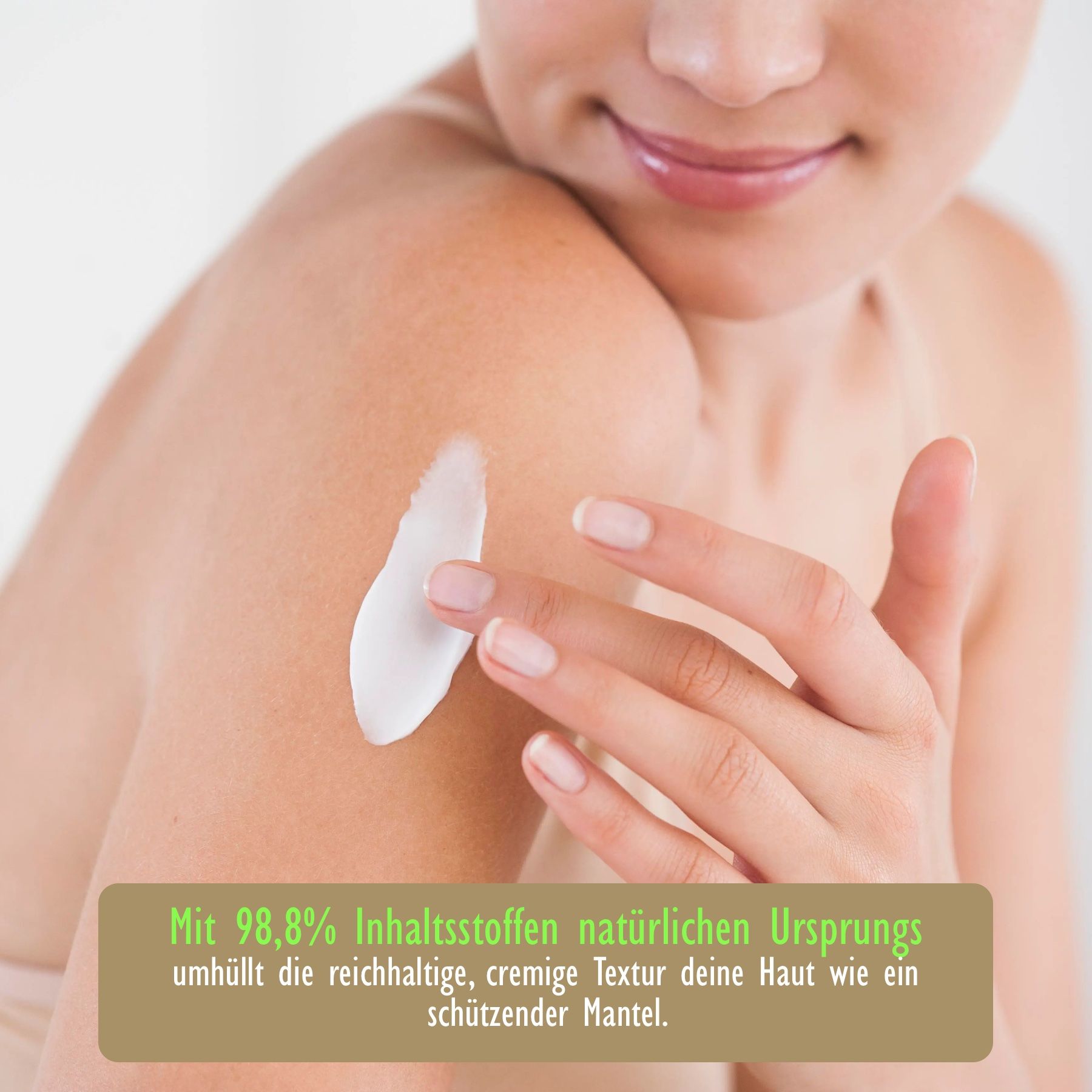 Nahaufnahme einer Person, die Creme auf ihren Arm aufträgt. Text: Mit 98,8% Inhaltsstoffen natürlichen Ursprungs.