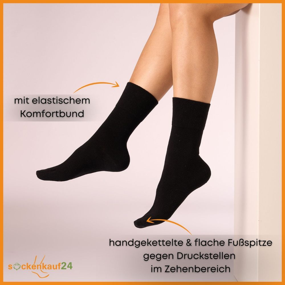 Zwei schwarze Socken am Bein. Text: Mit elastischem Komfortbund, handgekettelte & flache Fußspitze gegen Druckstellen.