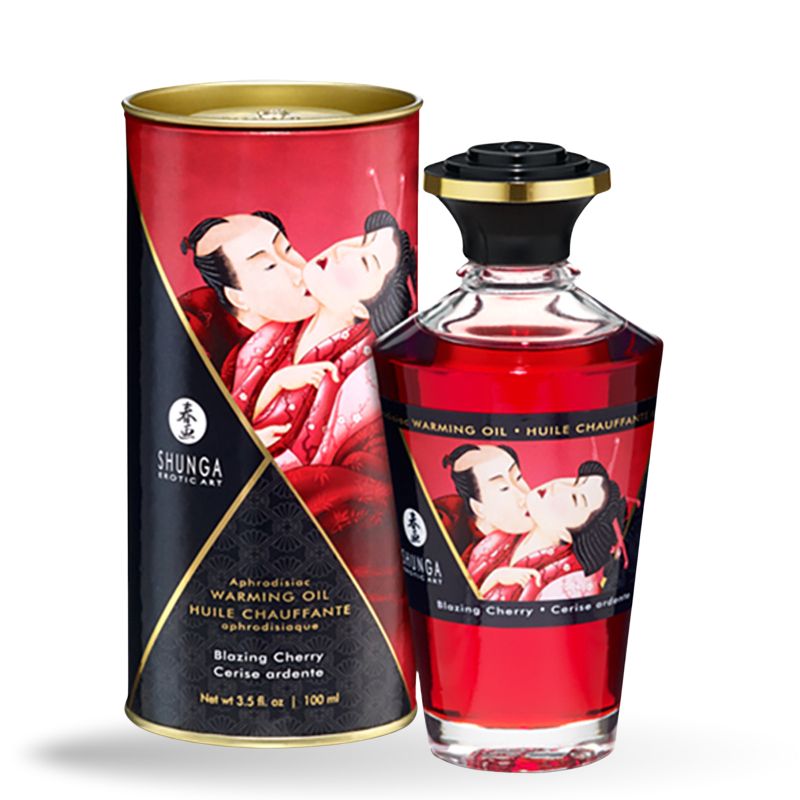 Rote Glasflasche mit schwarzem Deckel und roter Verpackung. Aufschrift: Shunga, Warming Oil, Blazing Cherry. Abbildung: küssendes Paar.