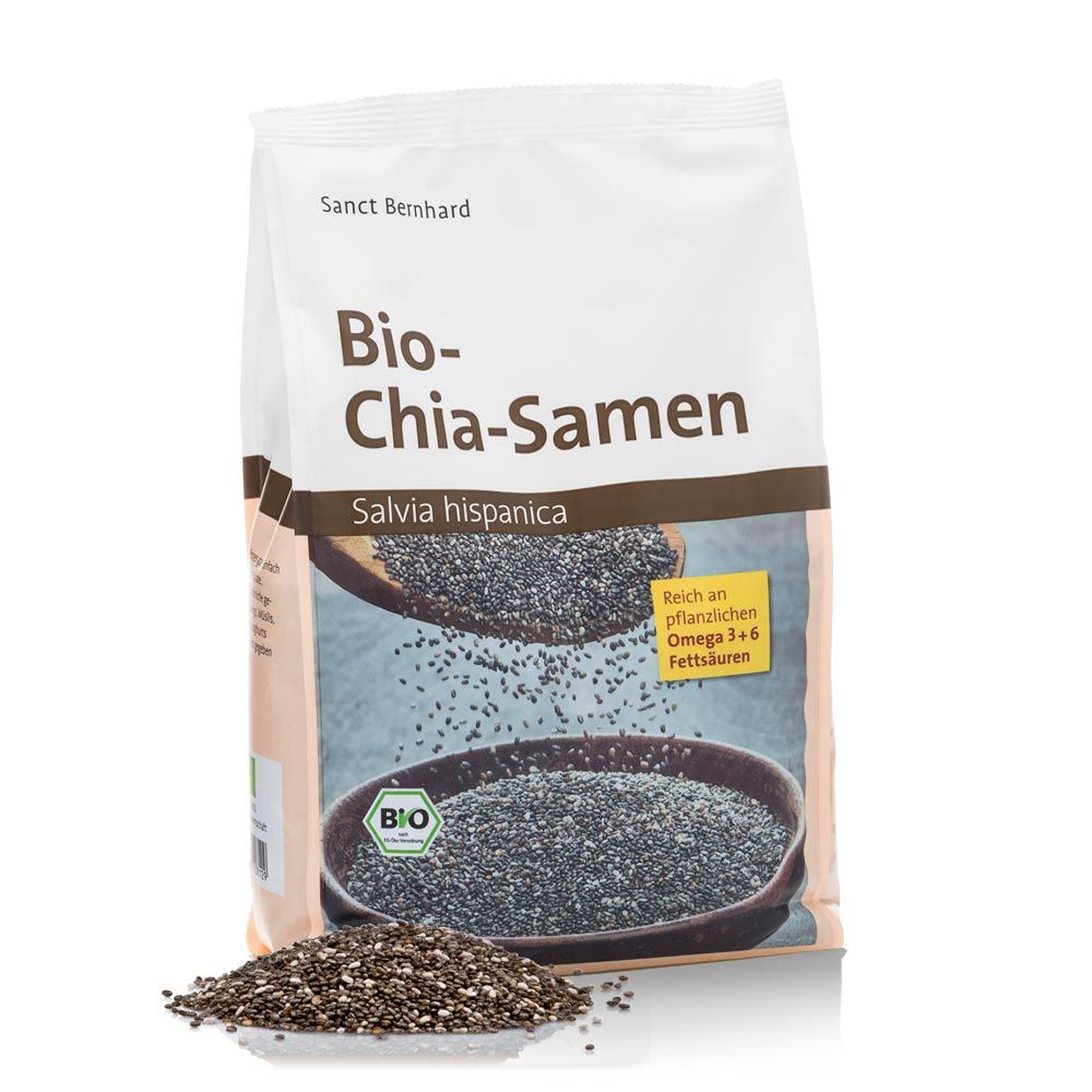 Beutel mit Bio-Chia-Samen. Aufdruck: "Sanct Bernhard", "Bio-Chia-Samen", "Salvia hispanica". Bio-Siegel. Samen auf braunem Hintergrund.
