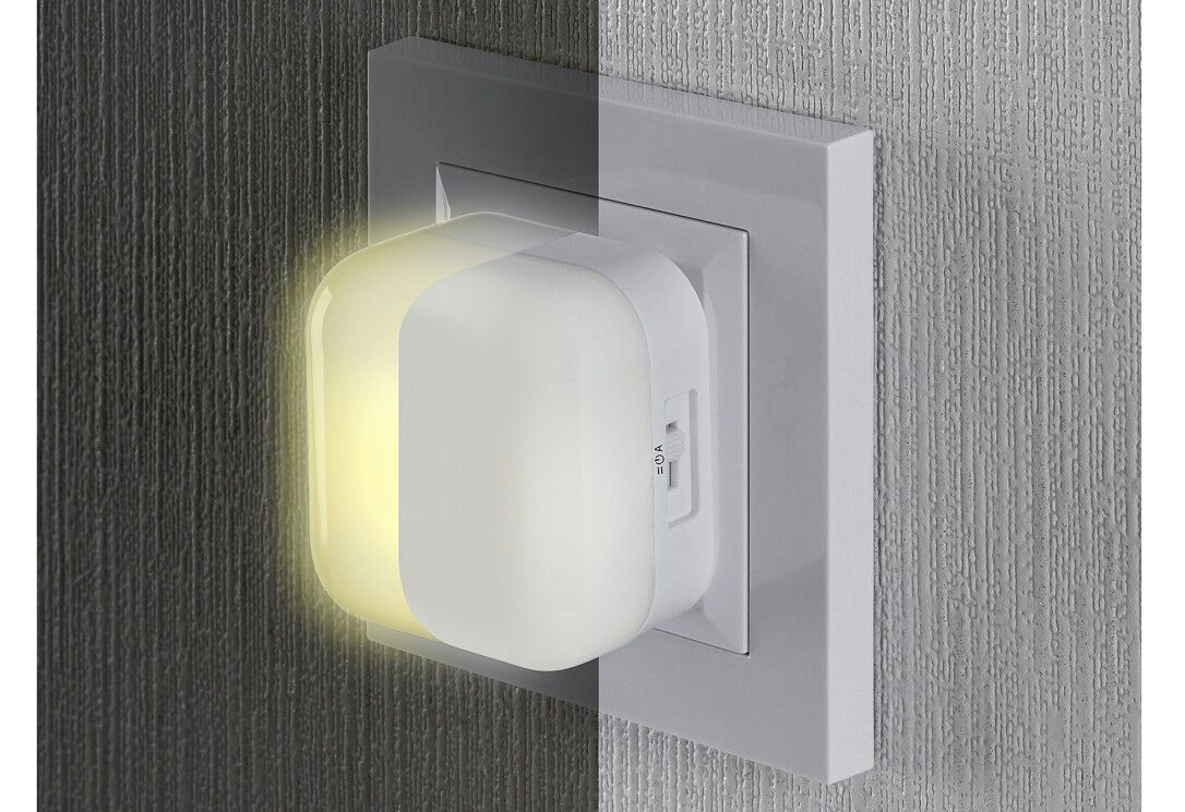 Nachtlicht in Steckdose. Weißes Gehäuse. Gelbes Licht. Schalter sichtbar. Marke: reer.