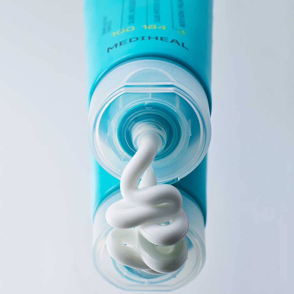 Nahaufnahme einer blauen Tube, aus der weiße Creme austritt. Marke MEDIHEAL. Der Deckel ist geöffnet.