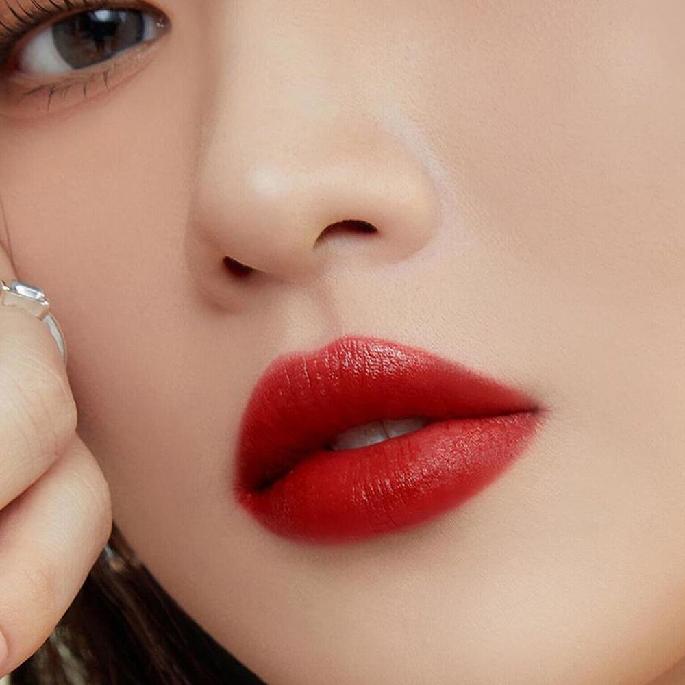 Nahaufnahme von Lippen mit rotem Lippenstift. Die Lippen sind voll und glänzend.