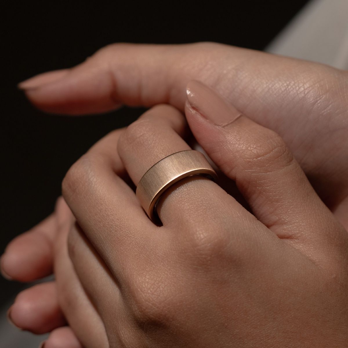 Goldfarbener Ring am Finger. Helle Haut. Ring aus Metall.