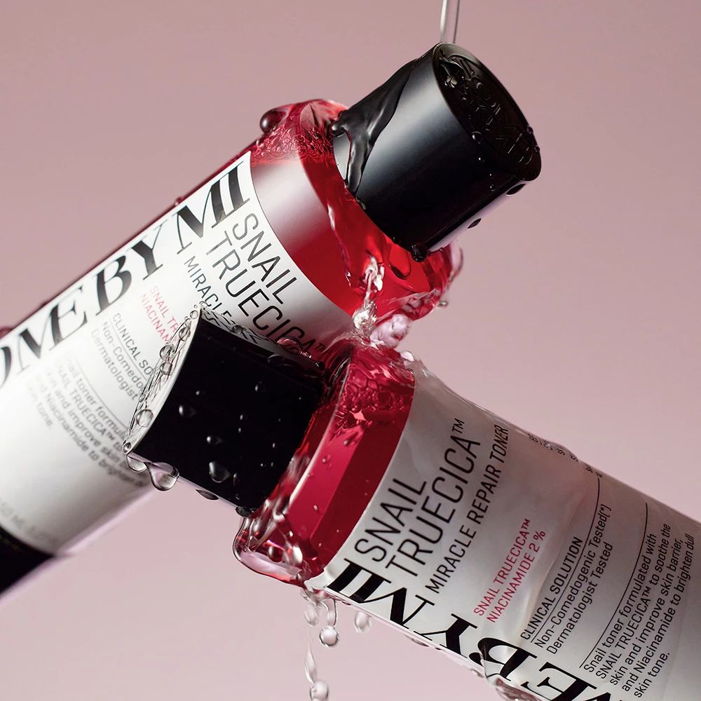 Zwei rote Flaschen, aus denen Flüssigkeit tropft. Auf den Flaschen steht SOME BY MI und Snail TrueCICA Miracle Repair Toner.