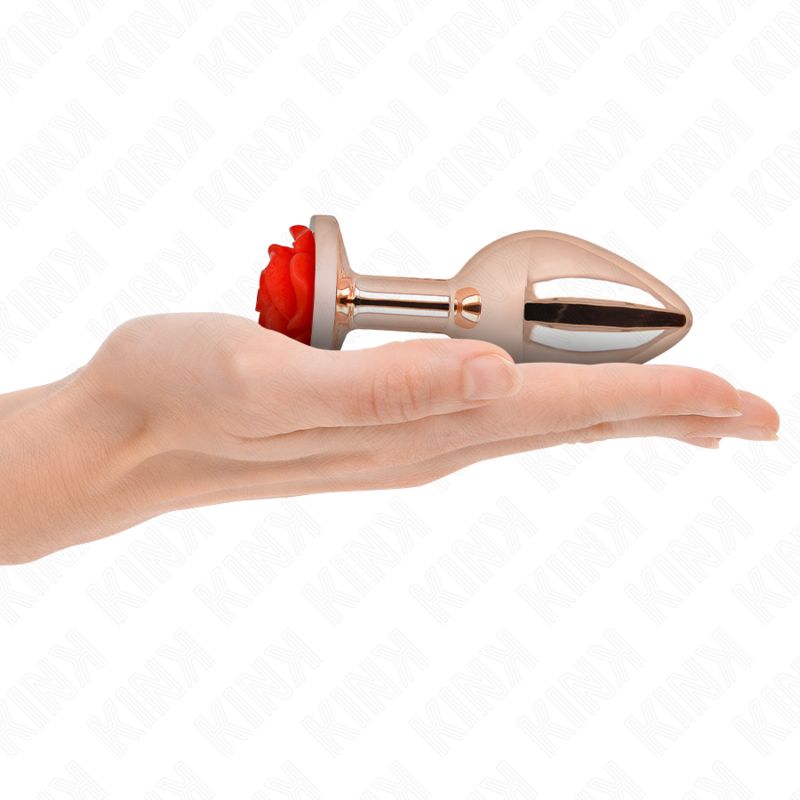 Hand hält einen Analplug aus Metall mit roter Rosen-Applikation.