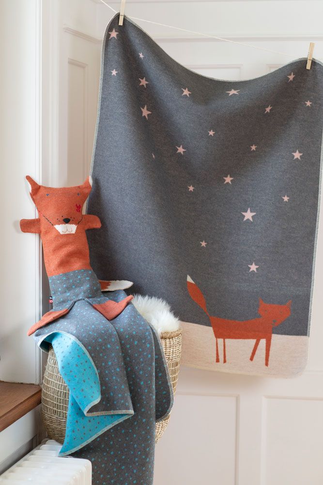 Graue Decke mit orangefarbenem Fuchs und rosa Sternen, aufgehängt.