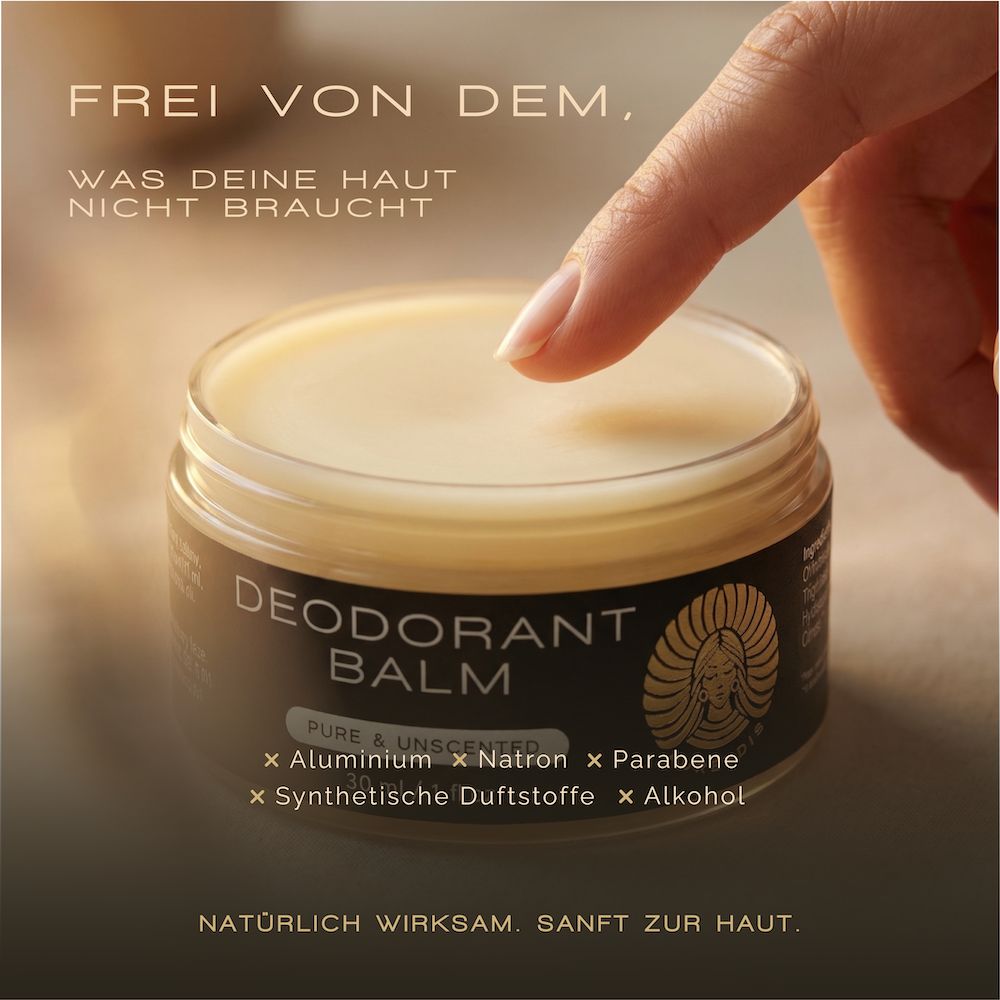 Ein offener Deodorant Balm-Tiegel mit einer Hand, die ihn berührt. Text: Frei von dem, was deine Haut nicht braucht.