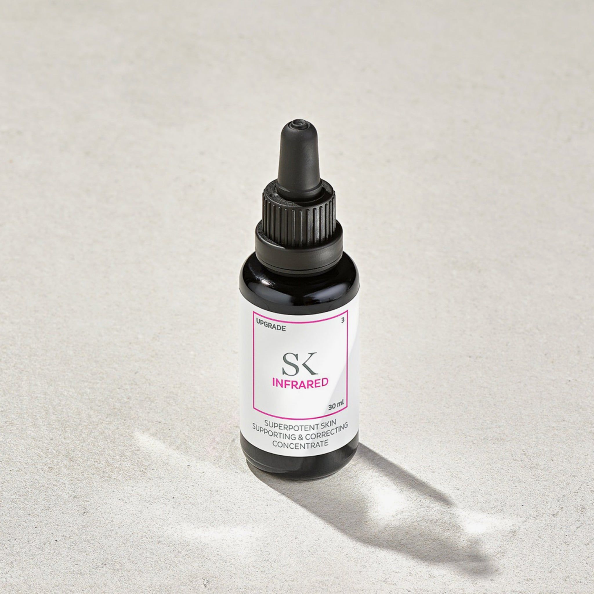 Dunkle Glasflasche mit schwarzem Verschluss und Pipette. Etikett mit "SK INFRARED" und Text. 30 ml.