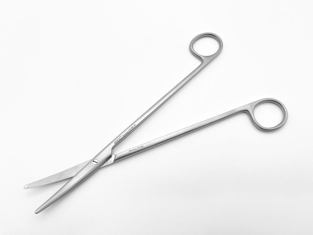 Geöffnete, gebogene chirurgische Schere. Metall, Ringgriffe, lange Schneiden. Aufschrift.