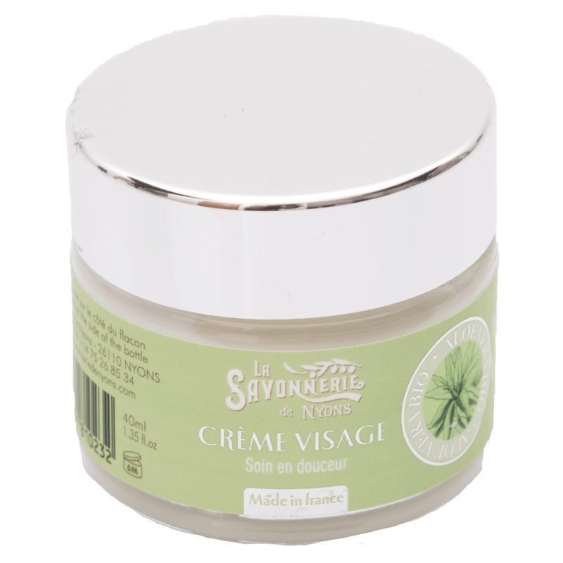 Creme-Glas mit silbernem Deckel. Aufschrift: La Savonnerie de Nyons, Crème Visage, Soin en douceur. Grünes Etikett mit Aloe Vera.