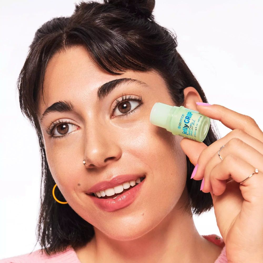 Frau hält grünen Primer-Stick. Aufschrift: essence jelly GRIP under eye primer stick.