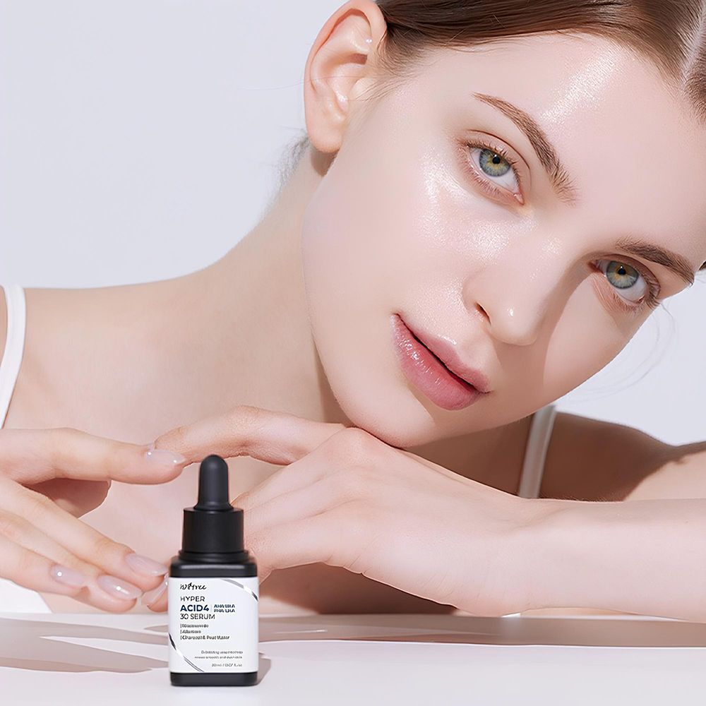 Frau mit Serumflasche. Flasche: Hyper Acid4 30 Serum. Enthält AHA, BHA, PHA, LHA. Mit Pipette.