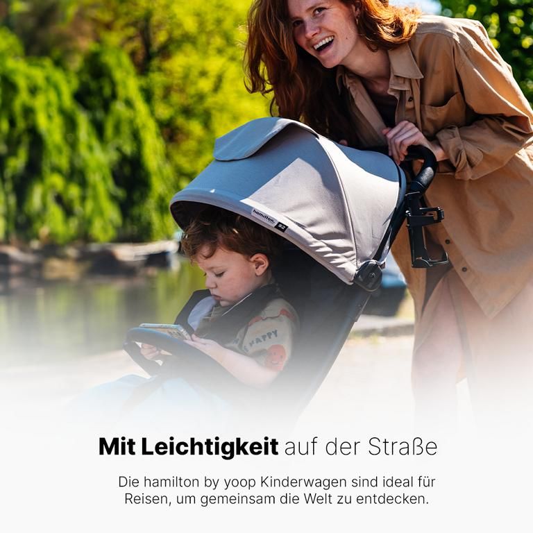 Kind sitzt in einem grauen Kinderwagen. Eine Person schiebt den Wagen. Text: Mit Leichtigkeit auf der Straße.