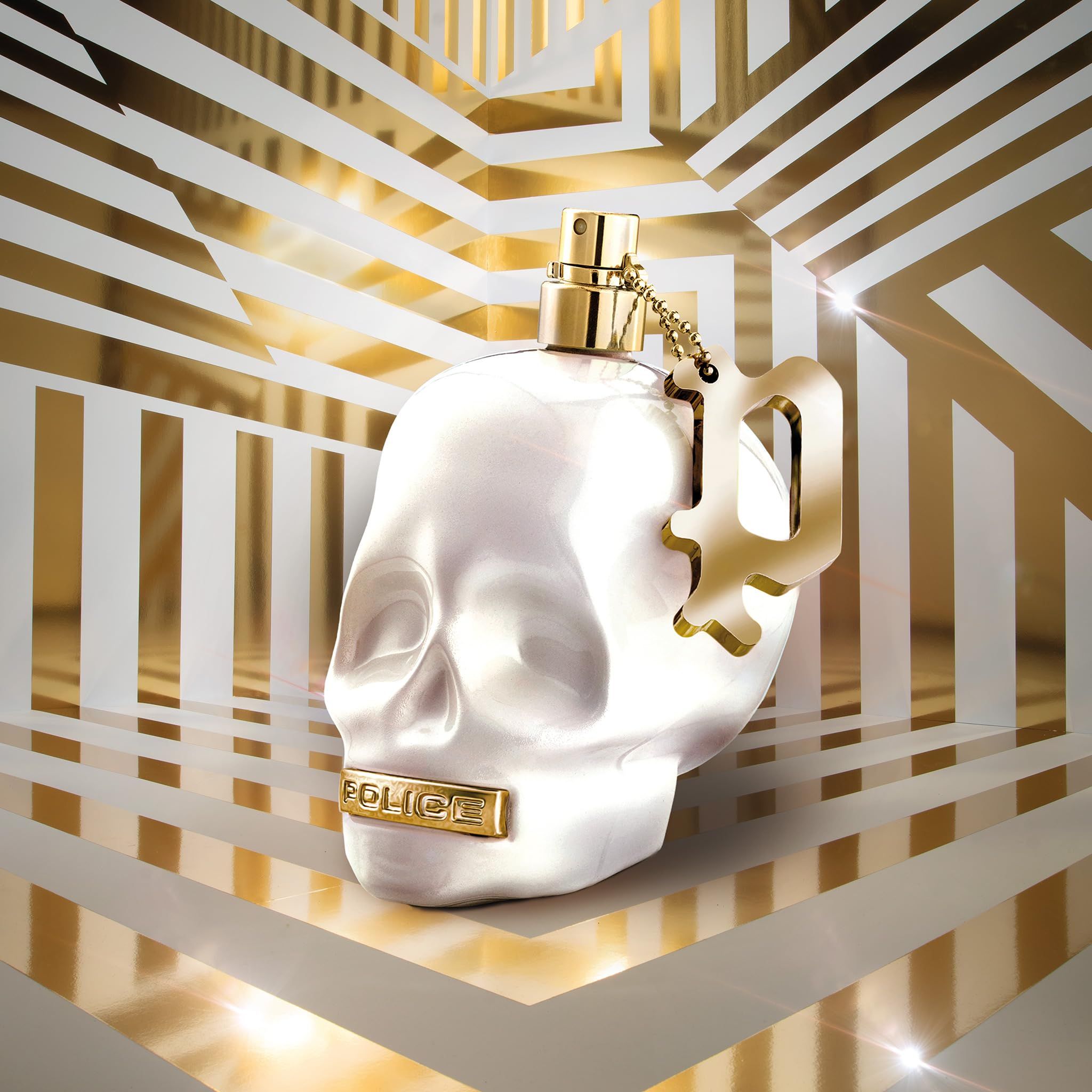 Parfümflakon in Schädelform mit goldfarbenen Details. Hintergrund mit goldenen Streifen.