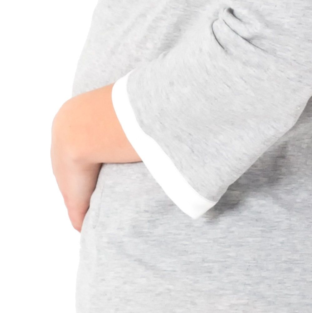 Detailaufnahme des grauen, melierten Langarm-Geburtsshirts. Weißer Saum am Ärmel.