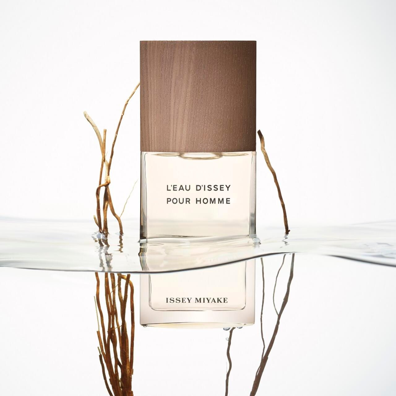 Flakon im Wasser mit Zweigen. Aufschrift: L'EAU D'ISSEY POUR HOMME und ISSEY MIYAKE. Holzdeckel.