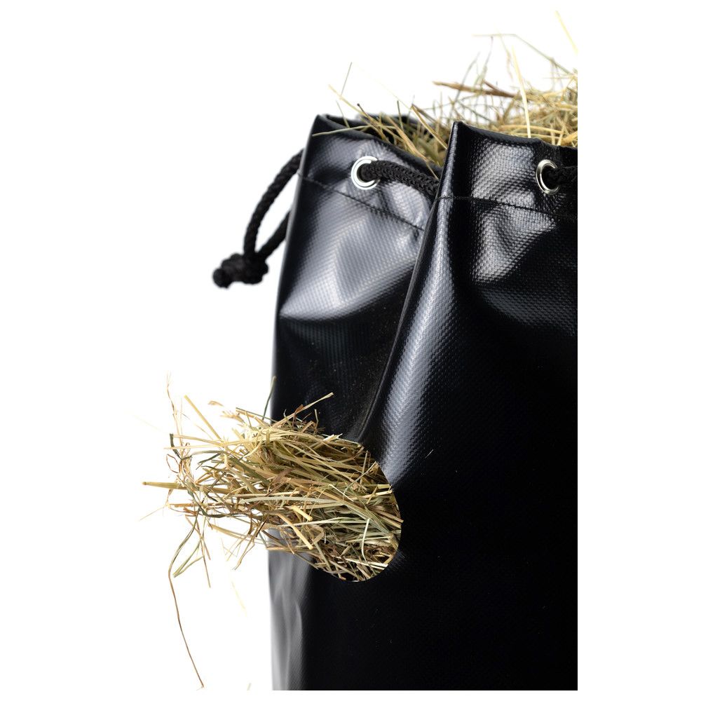 Nahaufnahme eines schwarzen Heusacks mit Heu. Lochöffnung für das Heu. Kordelzug und Ösen.