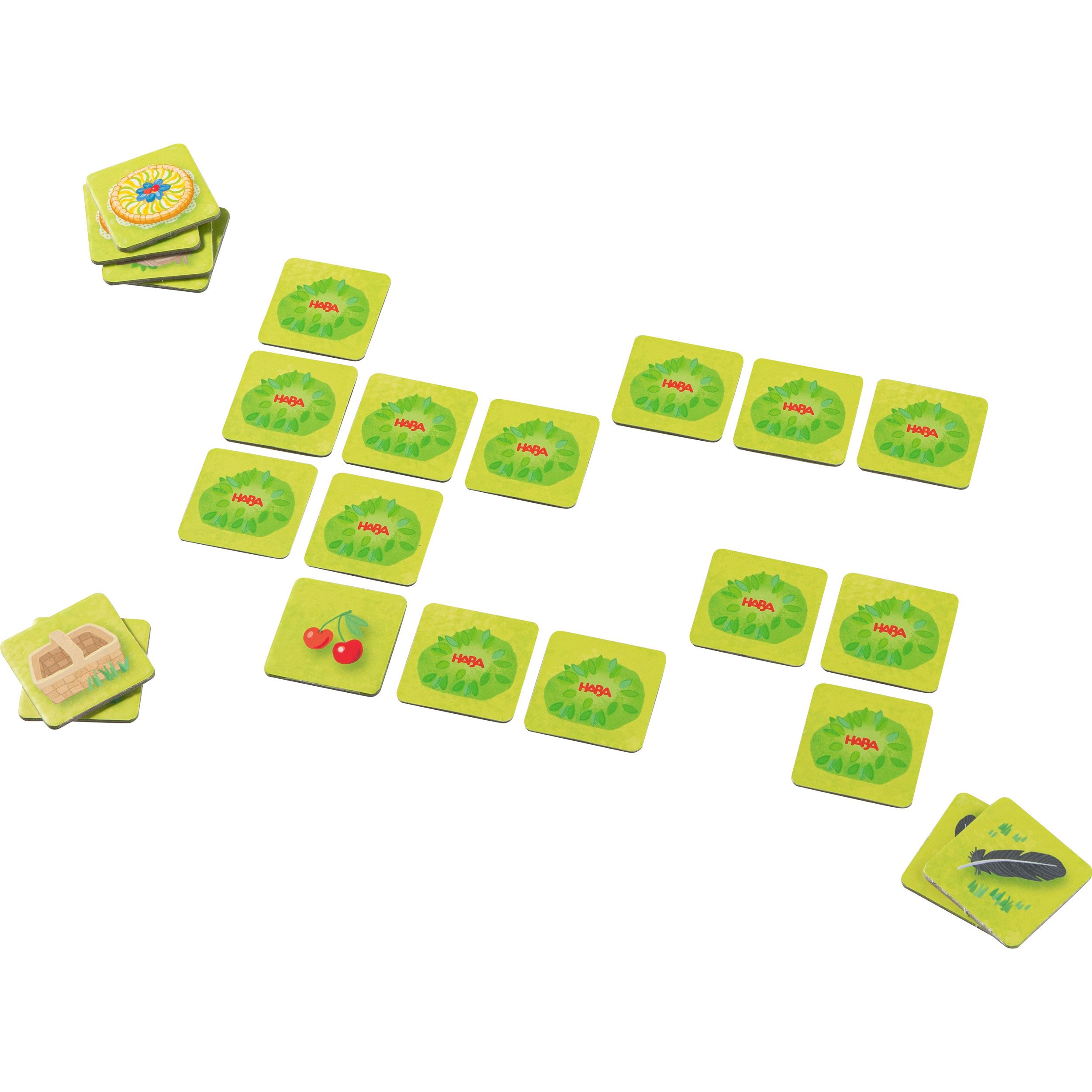 Spielkarten und Spielsteine mit Obstmotiven. Einige Karten zeigen Körbe. Auf weißem Hintergrund angeordnet.
