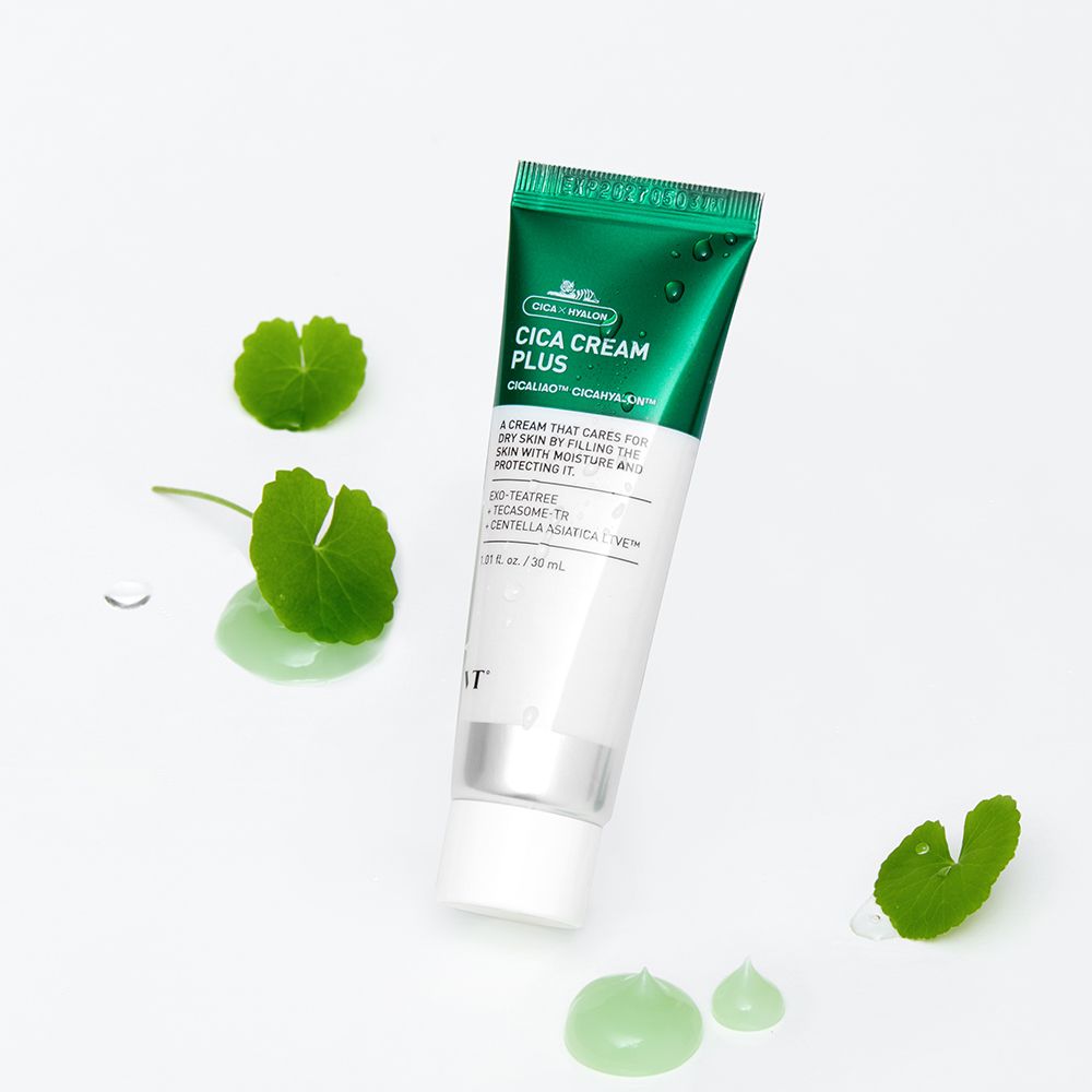 Cica Cream Plus Tube. Grün-weiße Tube mit Produktnamen und Inhaltsstoffen. Blätter und grüne Creme-Tropfen daneben.