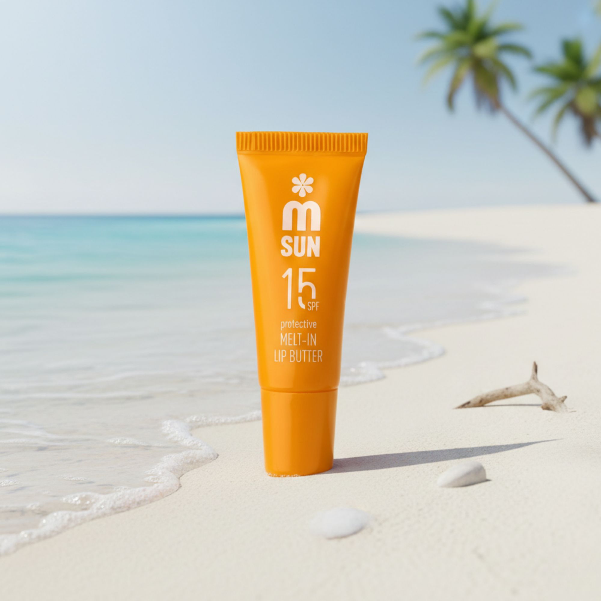 Orange Lippenbutter-Tube am Strand. Aufschrift: SUN 15 SPF, protective MELT-IN LIP BUTTER. Im Hintergrund Meer und Palmen.