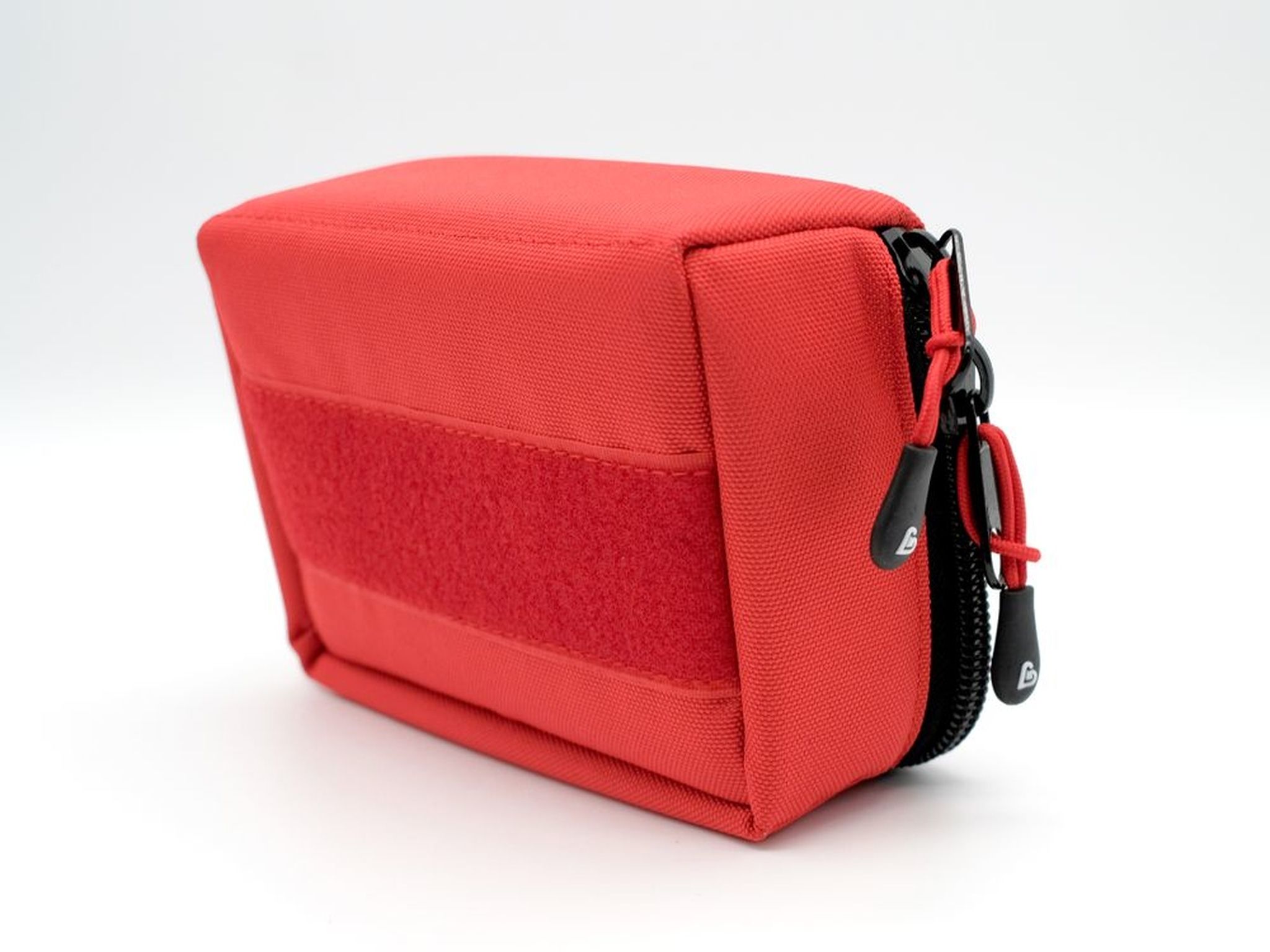 Rote Notfalltasche mit Klettverschluss-Fläche an der Seite und schwarzen Reißverschluss-Anhängern.