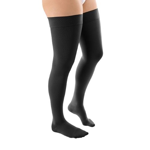 Schwarze Kompressions-Schenkelstrümpfe. Oberschenkelhoch, blickdichtes Material. Seitenansicht auf weißem Hintergrund.