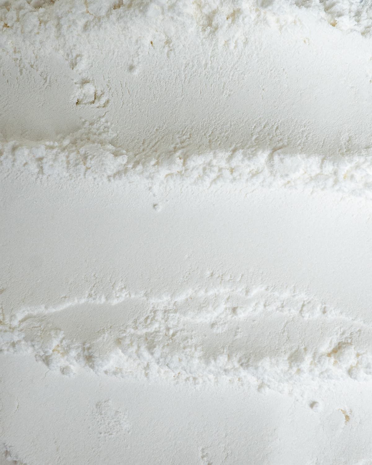 Nahaufnahme von weißem L-Histidin Base Pulver mit Streifenstruktur.