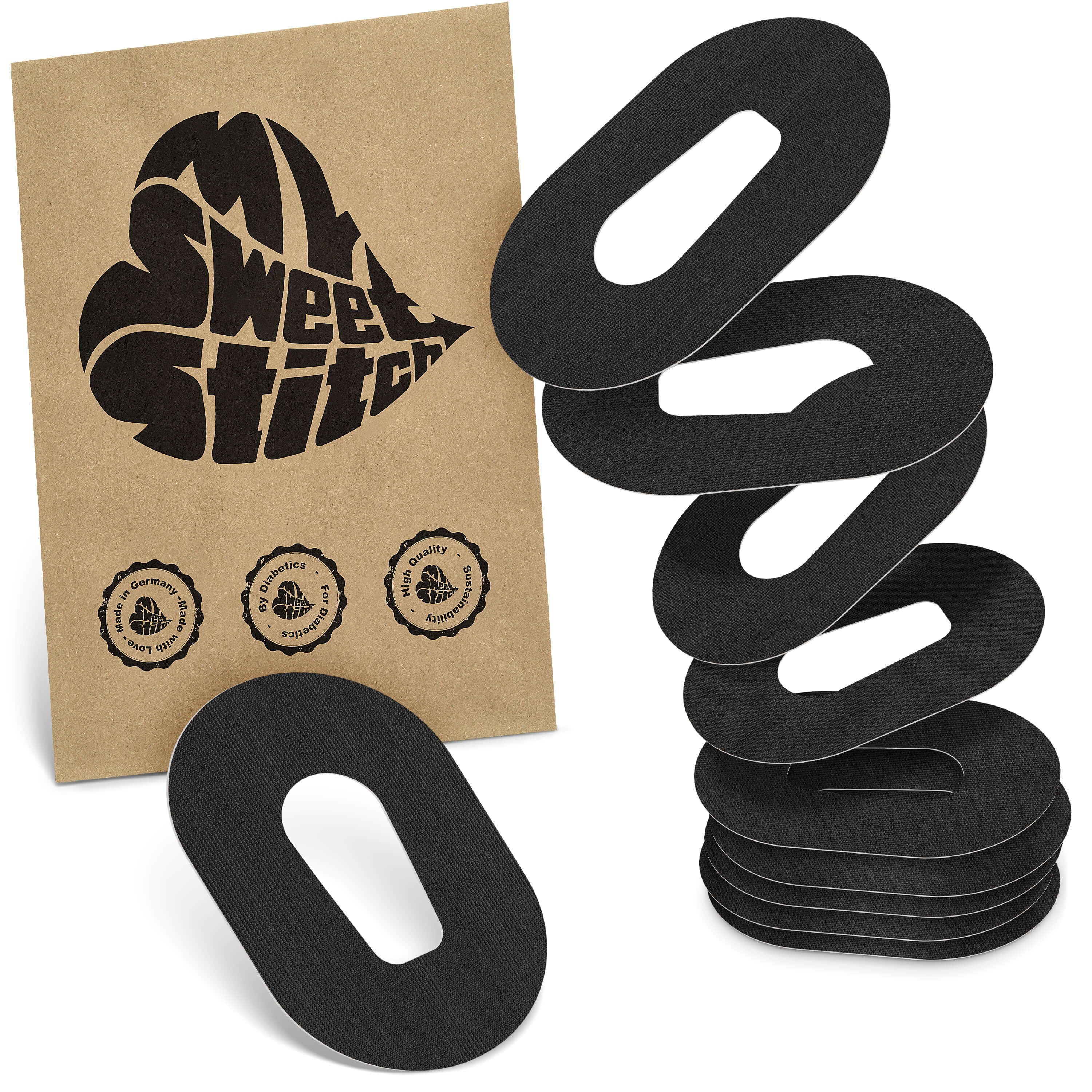 Braune Verpackung mit Logo. Daneben schwarze, ovale Pflaster mit Aussparung. Mehrere Pflaster gestapelt.