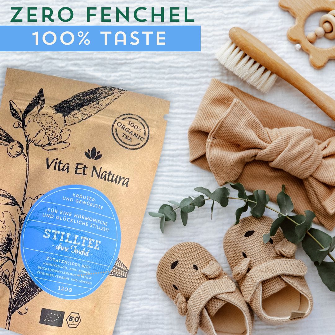 Stilltee-Packung, daneben Baby-Accessoires: Haarreif, Schuhe, Bürste. Aufdruck: Vita Et Natura, Kräuter- und Gewürztees, Stilltee.
