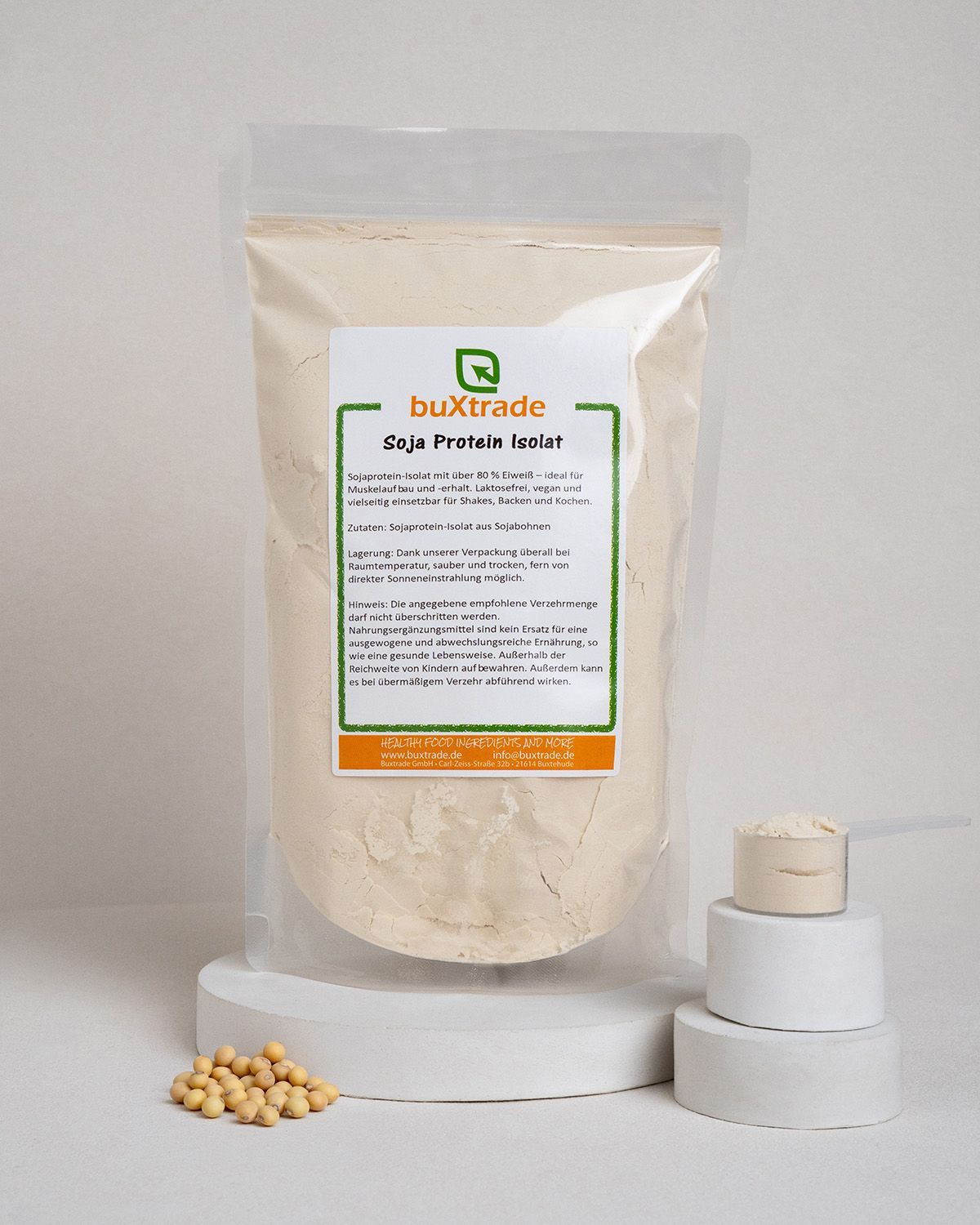 Transparente Verpackung mit Pulver, Messlöffel und Sojabohnen. Etikett zeigt 'buXtrade Soja Protein Isolat'.