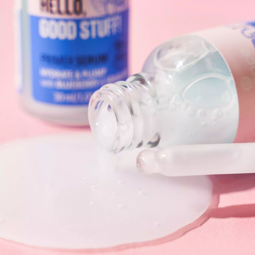 Produktflasche und Serum auf rosa Untergrund. Pipette liegt daneben. Aufschrift: Hello, Good Stuff!, Primer Serum.