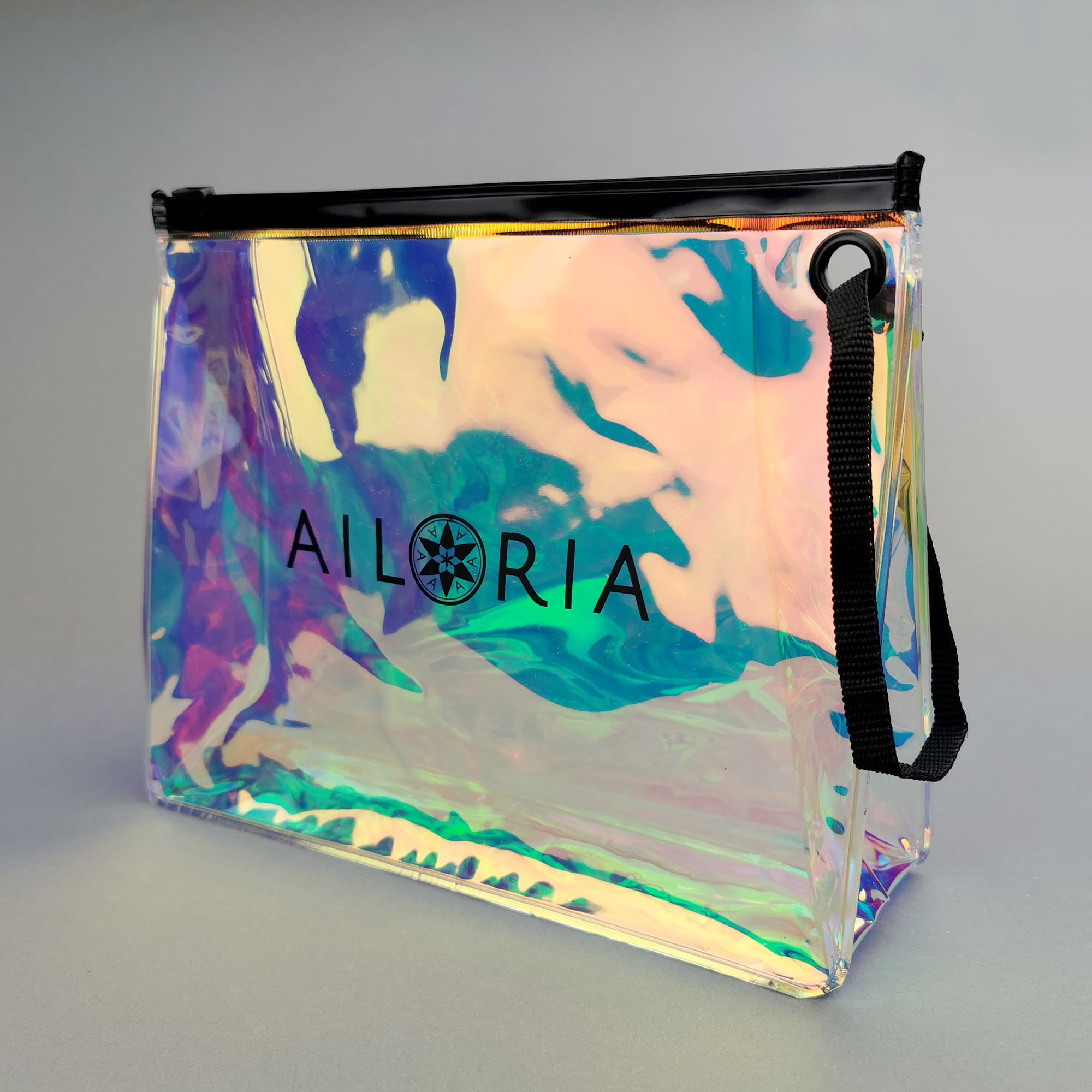 Transparente Tasche mit AILORIA-Logo. Schwarzer Reißverschluss und Tragegriff. Holografischer Effekt.