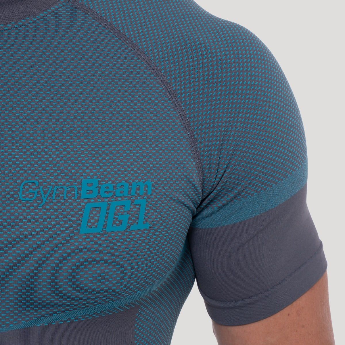 Detailansicht des GymBeam OG1 Logos auf einem grauen Herren-T-Shirt mit blauen Akzenten.