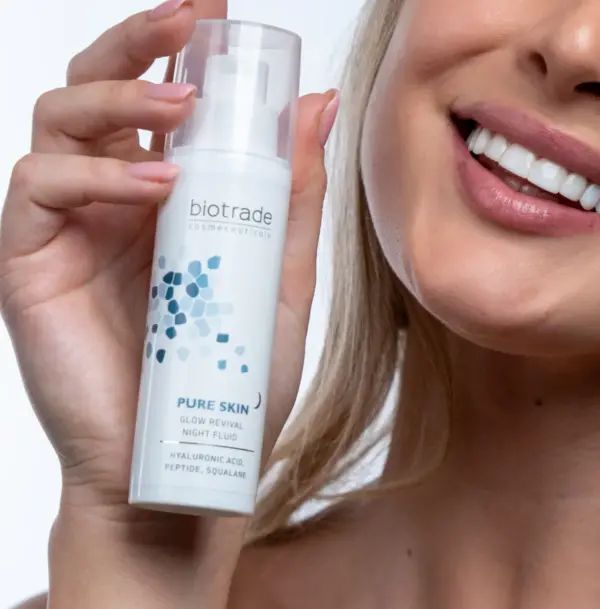 Weißes Fläschchen mit Pumpe und transparentem Deckel. Aufschrift: Pure Skin Glow Revival Night Fluid. Produkt wird von einer Person gehalten.