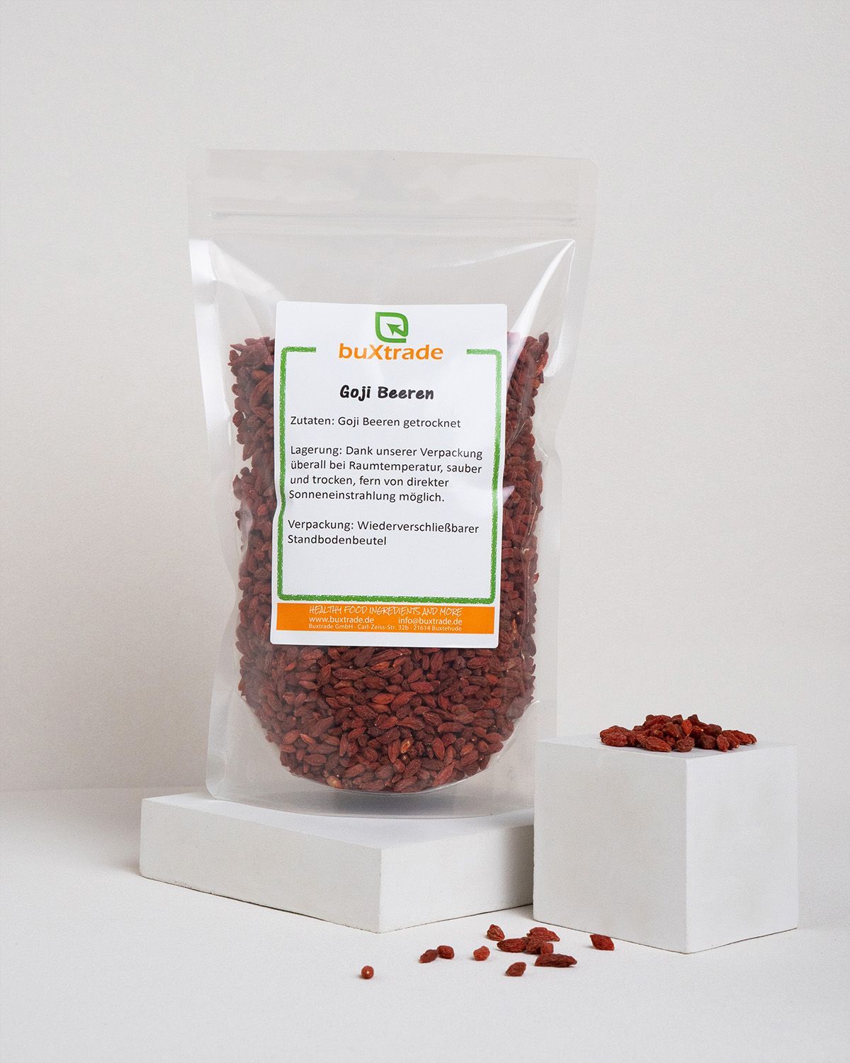 Transparenter Beutel mit Goji-Beeren auf einem weißen Podest. Marke: buXtrade.