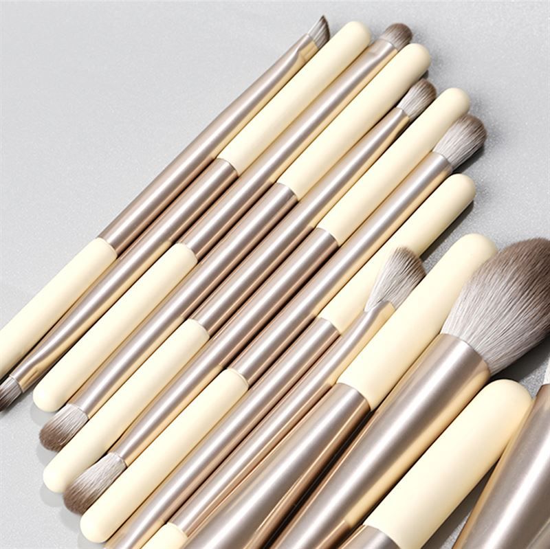Make-up Pinsel-Set. 12 Pinsel mit cremefarbenen Griffen, silbernen Hülsen und verschiedenen Pinselköpfen.