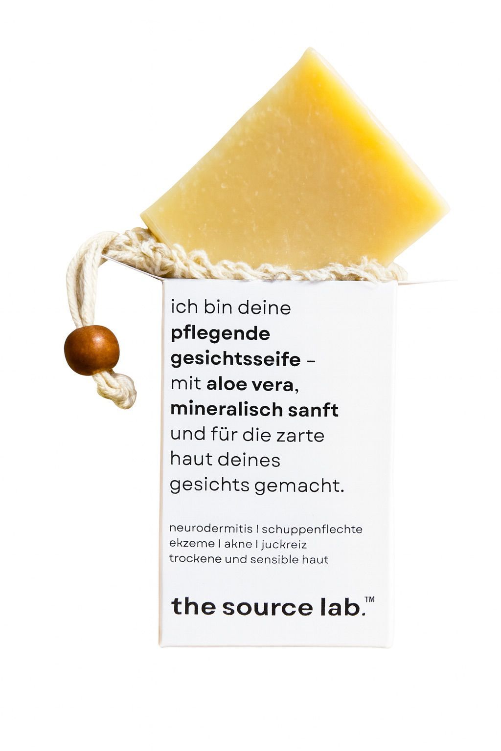 Seife mit Etikett. Etikett mit Text: 'pflegende Gesichtseife - mit aloe vera, mineralisch sanft'. Marke: 'the source lab'.