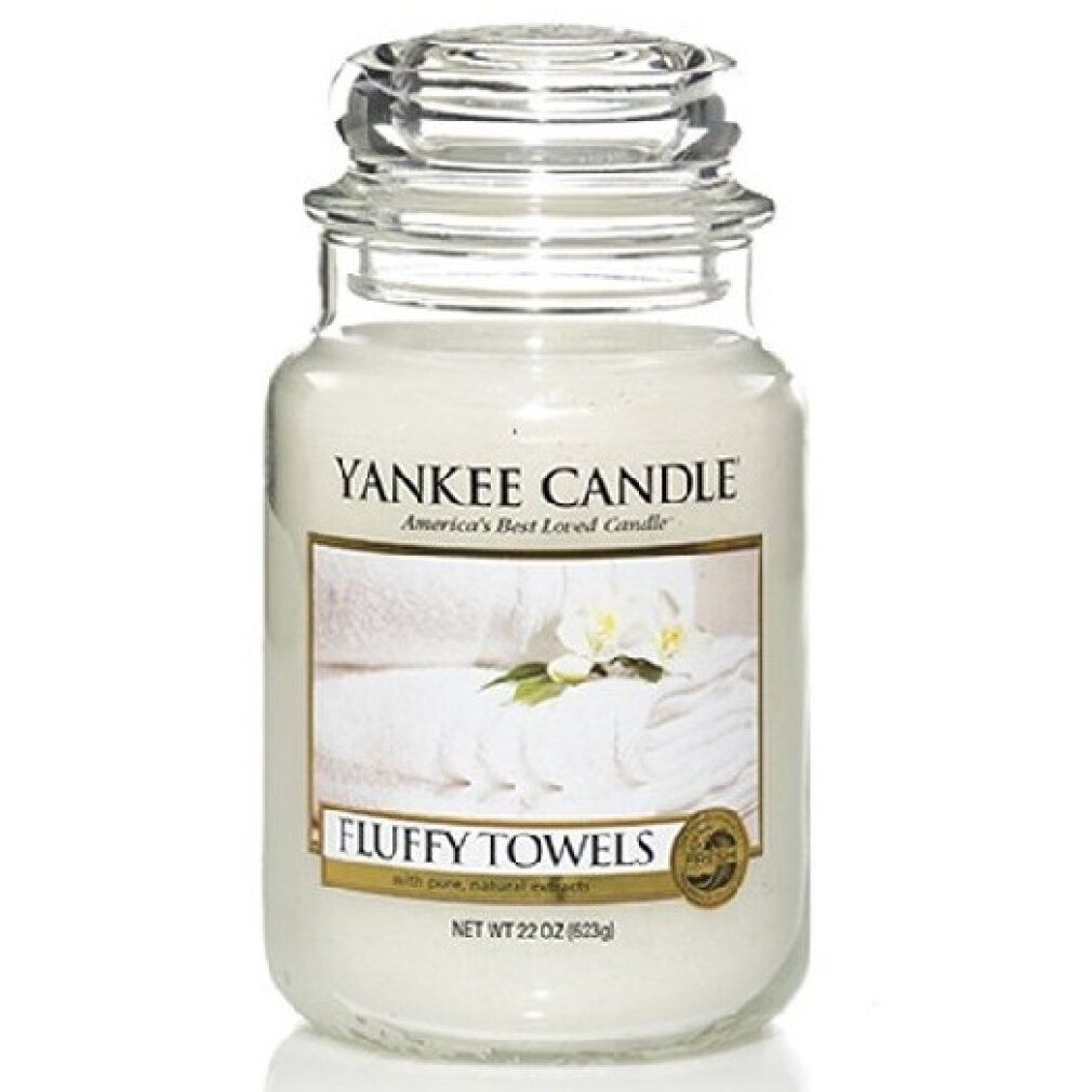 Yankee Candle Duftkerze Fluffy Towels. Glasbehälter mit Deckel. Etikett mit Handtüchern und Blüten. Netto 22 oz (623g).