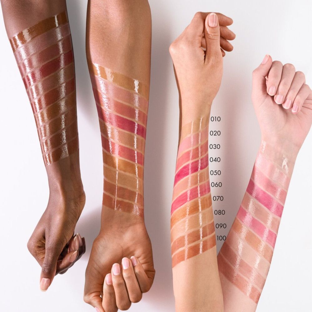 Arme mit aufgetragenen Lipgloss-Farben in verschiedenen Farbtönen. Farbnummern von 010 bis 100.