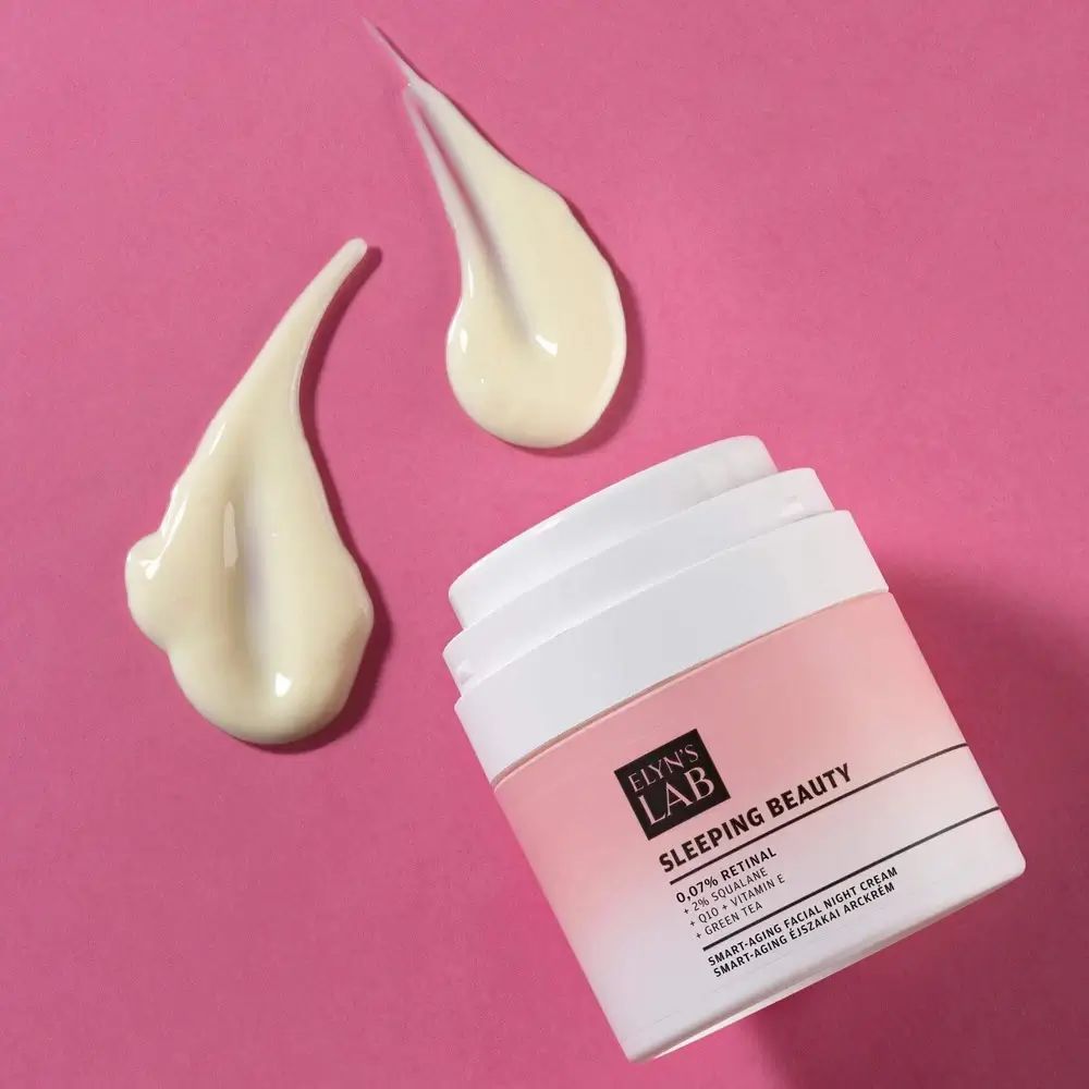 Cremebehälter mit weißem Deckel und rosa Etikett. Daneben drei Cremespritzer. Text: ELYN'S LAB, SLEEPING BEAUTY, 0,07% Retinal, +2% Squalan, +Q10 + Vitamin E.