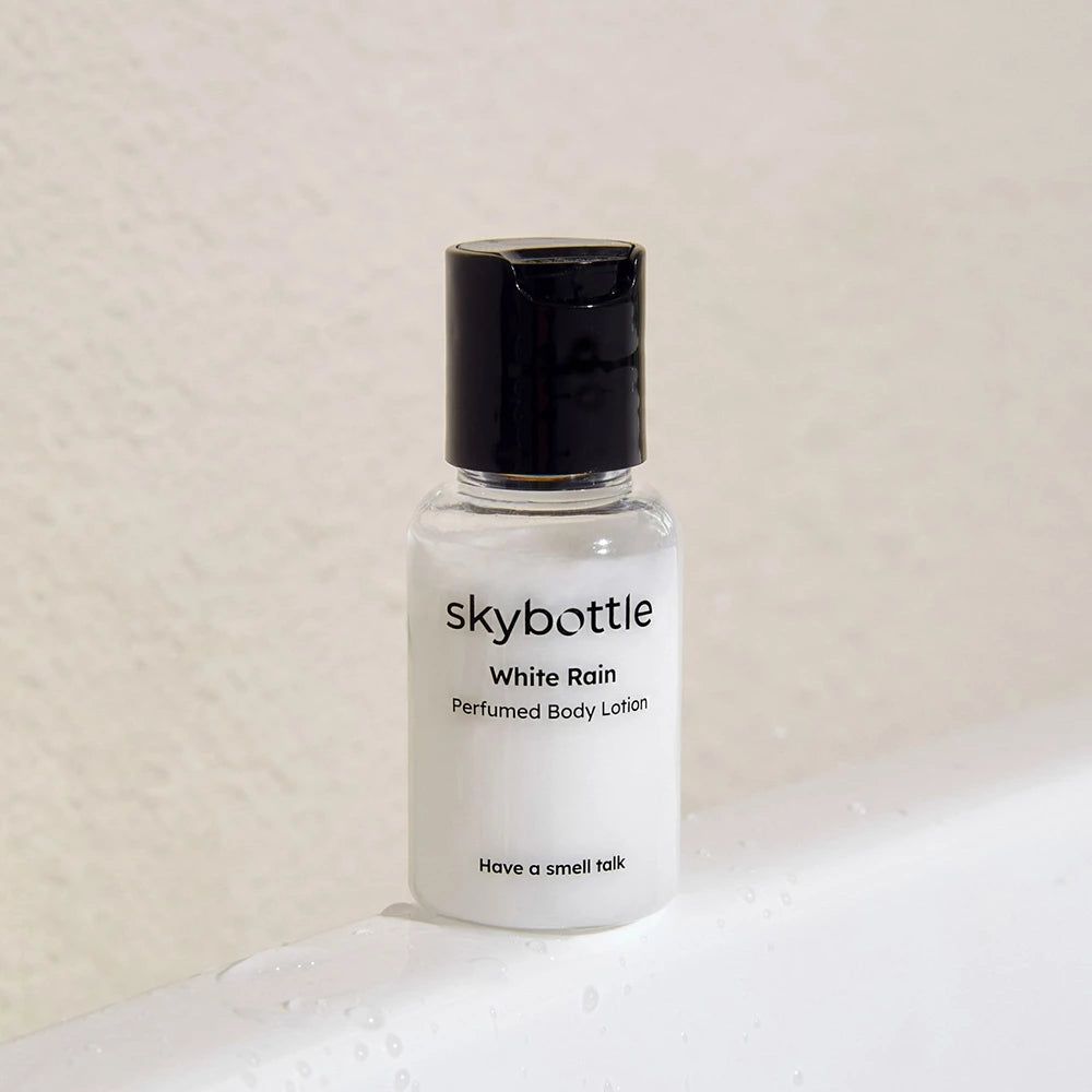 Körperlotion-Flasche, weiß, schwarzer Deckel. Aufschrift: SKYBOTTLE White Rain Parfümierte Körperlotion.